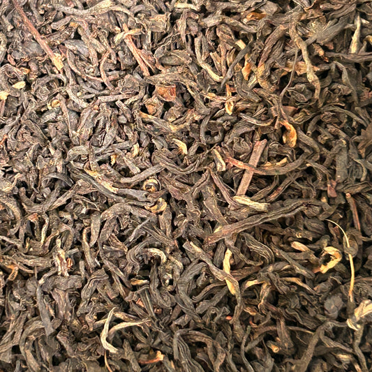 Loose leaf Assam black tea with rich, malty leaves in a glass cup